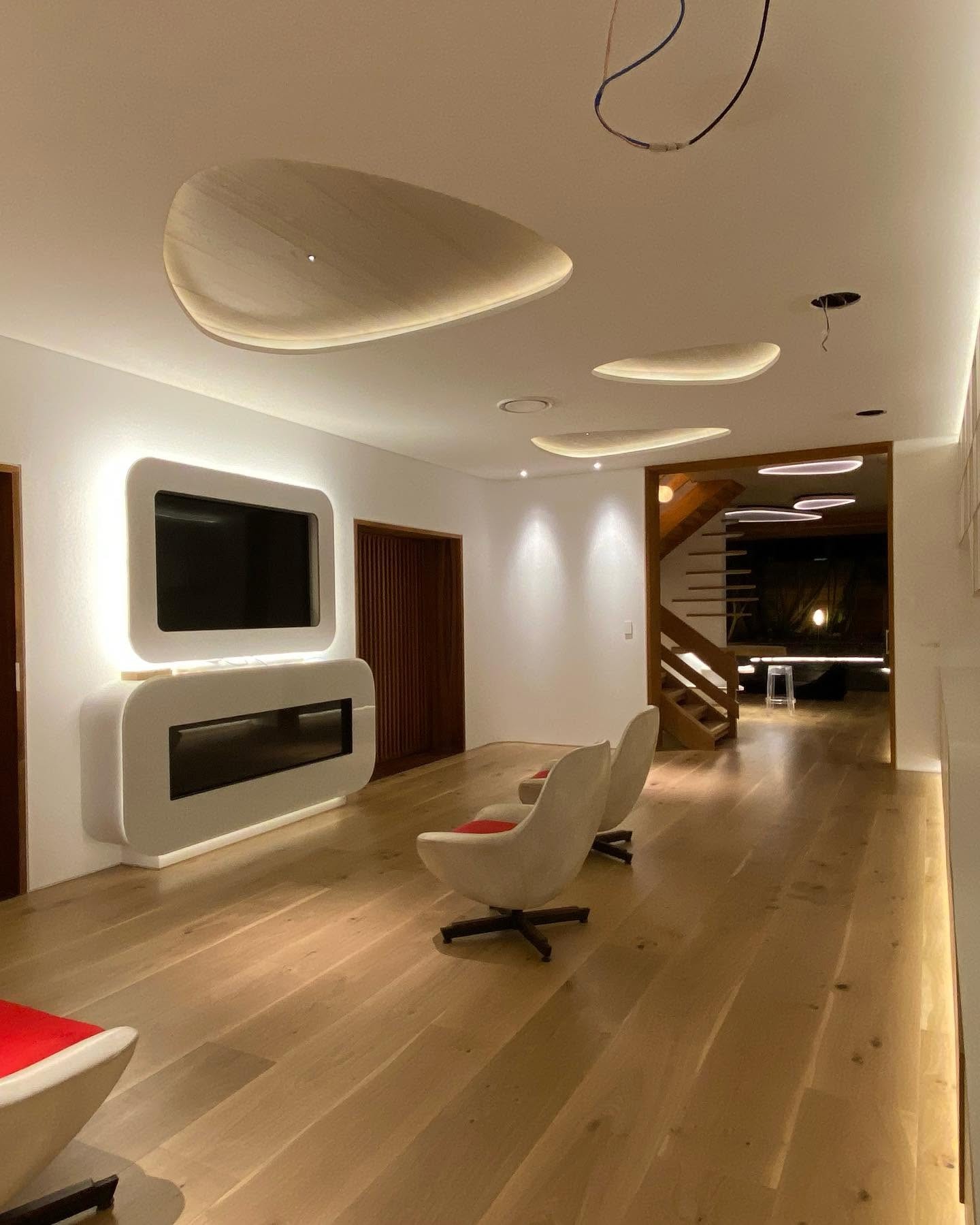 Contemporary lounge with a wide-board oak floor and warm architectural lighting