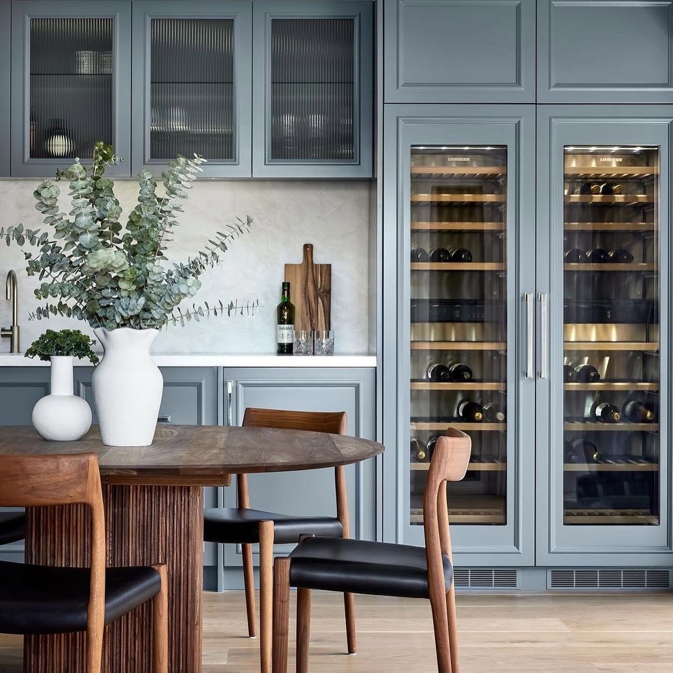 Blue-grey butler’s pantry and dining nook with an oak floor